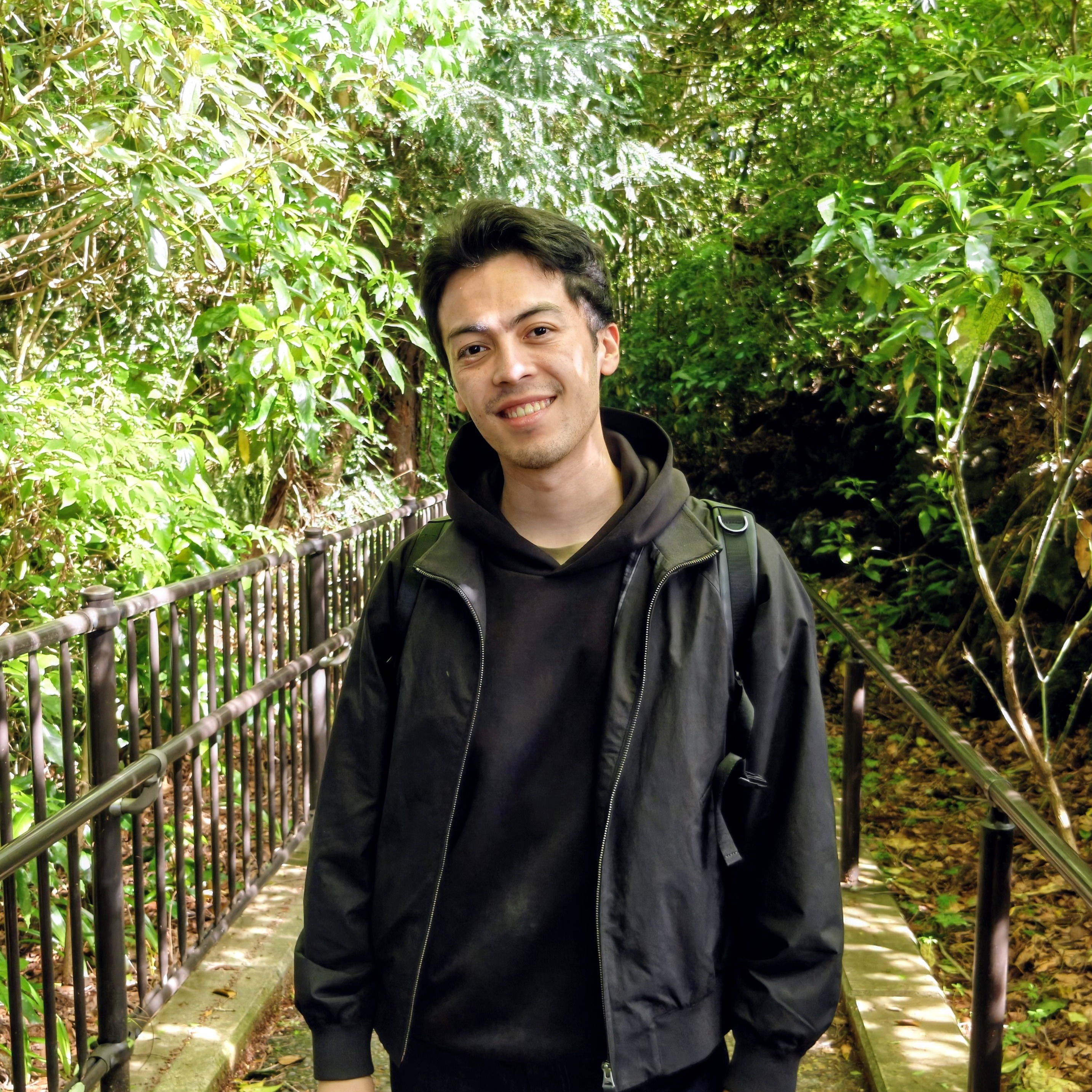 Alex Blanco sonriendo en un sendero rodeado de vegetación