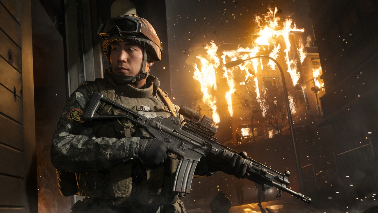 Un soldado armado vigila frente a un edificio en llamas en Modern Warfare 4